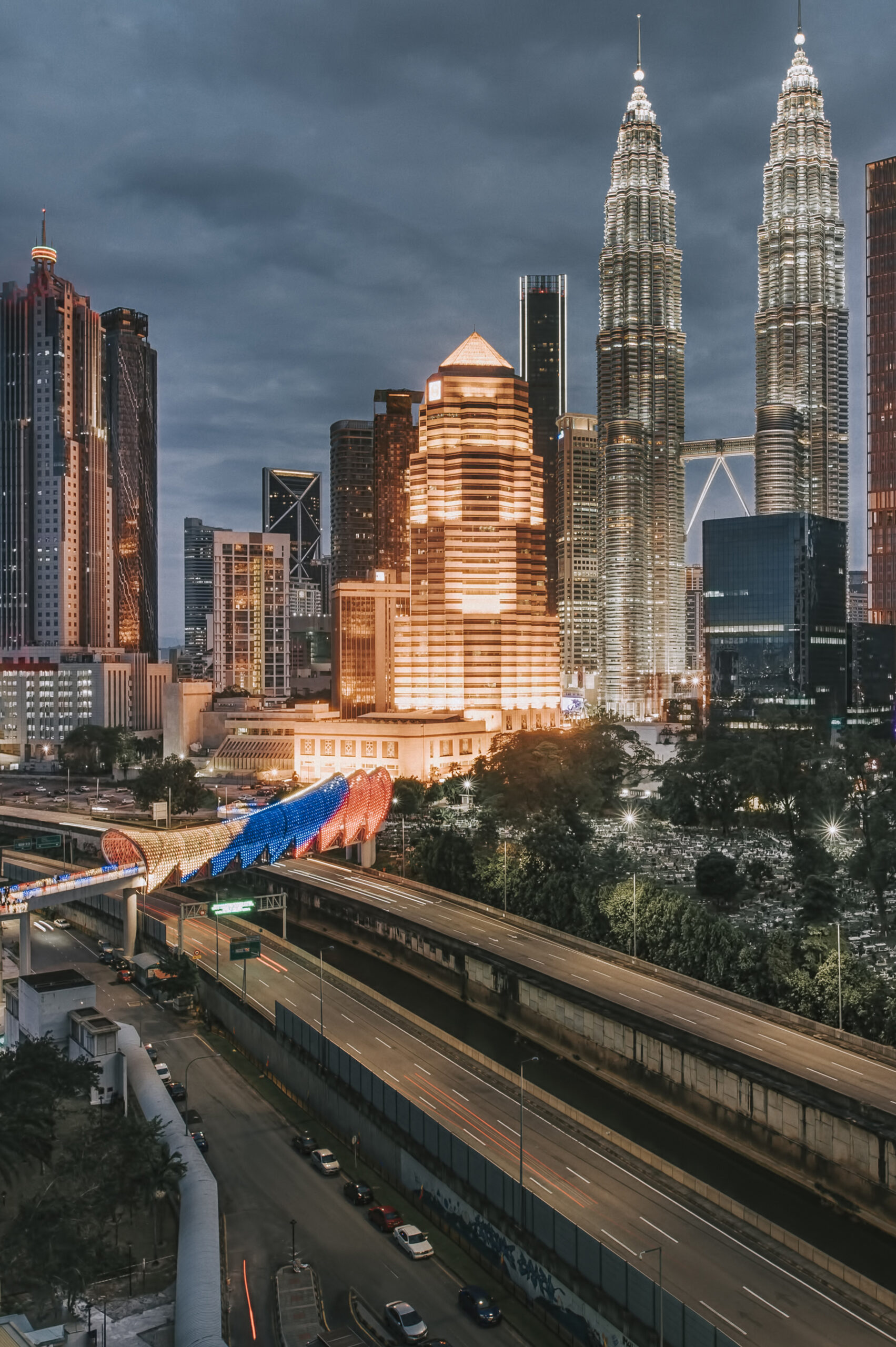 Kuala Lumpur Cityscape at night with bridge connection in between old town and new city buildings across highway